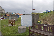 NU2519 : Concrete cubes and rabies sign above Craster Harbour by Phil Champion