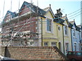 Scaffolding on end of pastel coloured terrace near Petersfield Station